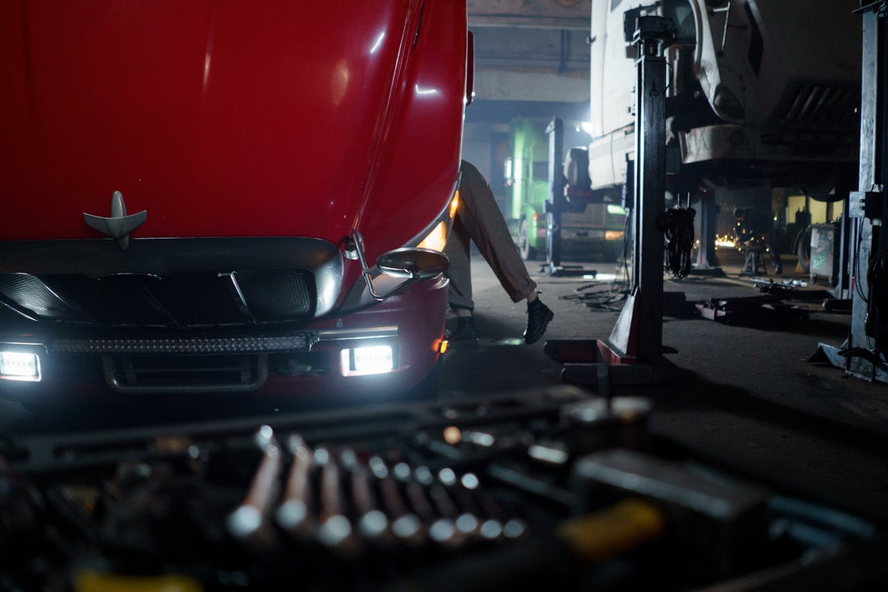 services-03 Mechanic working on a truck in a dimly lit garage, focused on repair and maintenance.